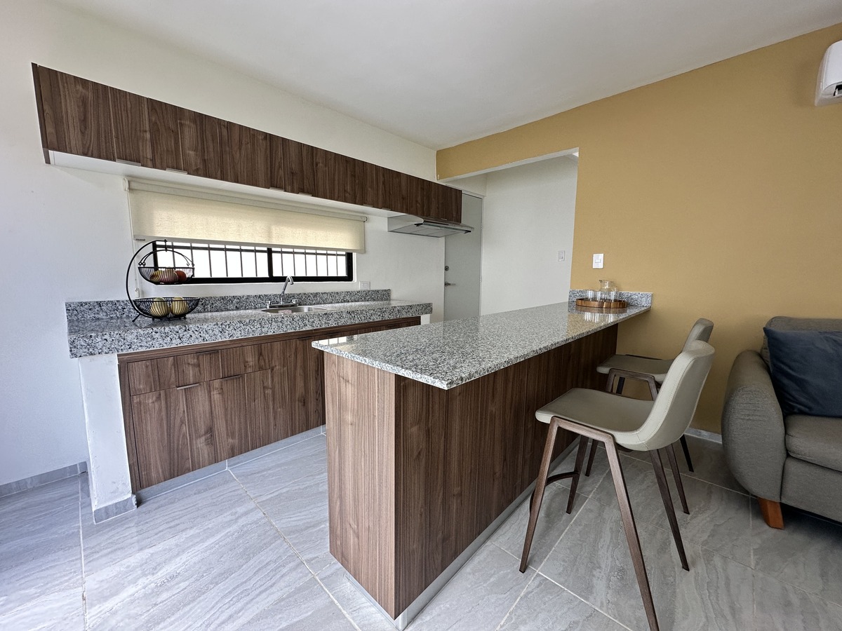 Cocina moderna con barra de granito y extractor - Casa Modelo Belén